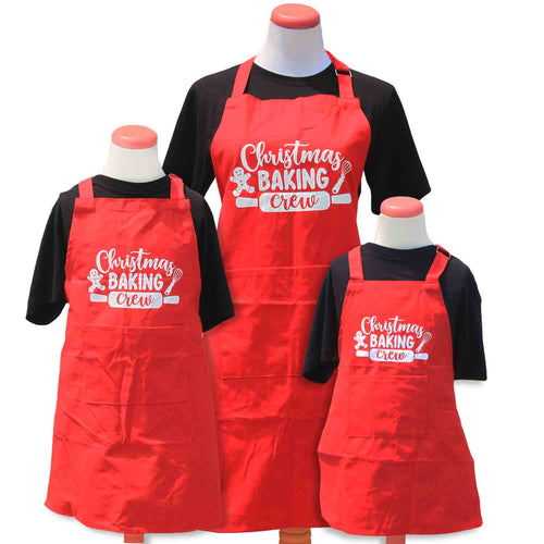 three red aprons in different sizes with Christmas Baking Crew printed.